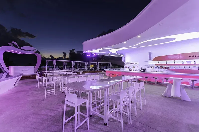 White and pink open-air Bash Bar illuminated at night