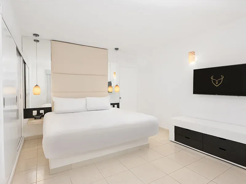 Deluxe Garden View room with white king bed and warm pendant lights