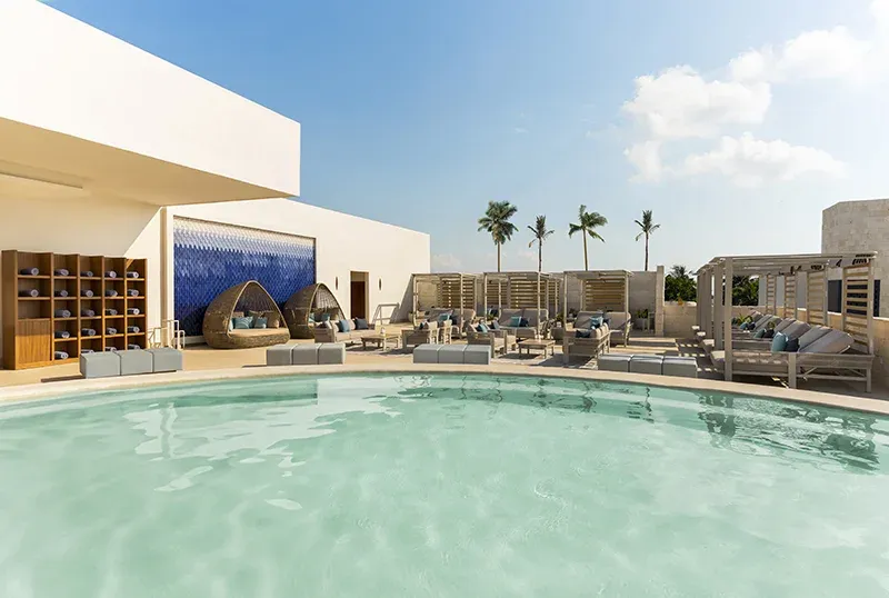 Open-air Jacuzzi Lounge with pool, daybeds, and shaded seating