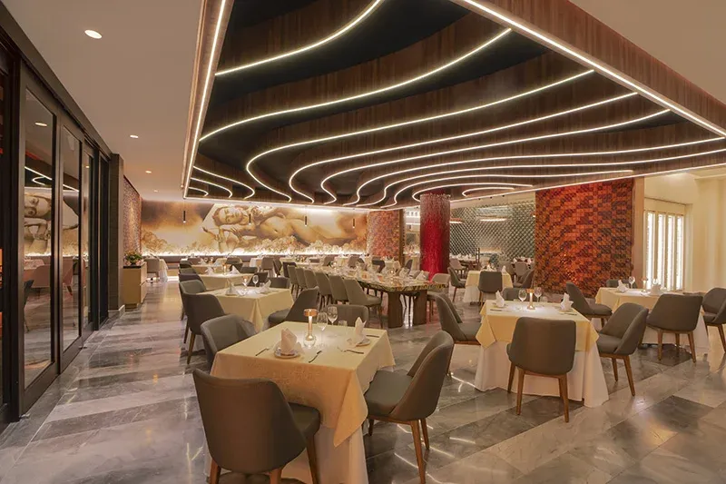 Kahlo restaurant dining room with curved ceiling lights and set tables