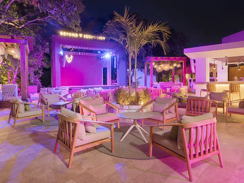 Open-air Melange lounge with seating and illuminated stage at night