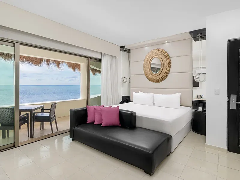 Oceanfront Passion Suite bedroom and sitting area overlooking the Caribbean