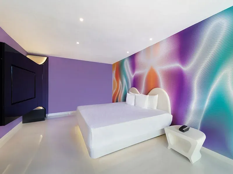 Trendy Garden View room with white bed and colorful feature wall