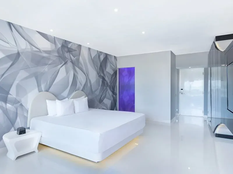 Trendy Ocean View room with white bed and silver feature wall